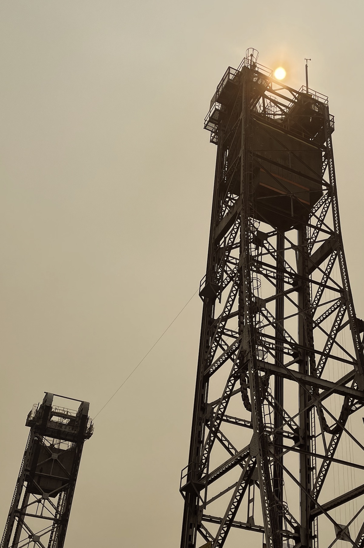 Two iron structures stand against a dead, orange sky.