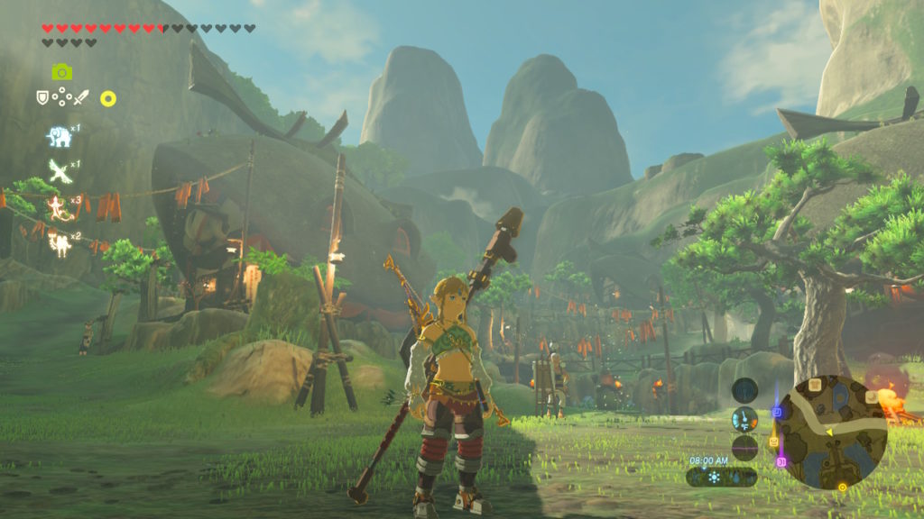 Screenshot from The Legend of Zelda: Breath of the Wild of the androgynous hero character, Link, dressed in a crop top and rubber pants, with an extremely large drill-headed weapon on his back. The background is beautiful mountains beyond a Japanese-styled village.