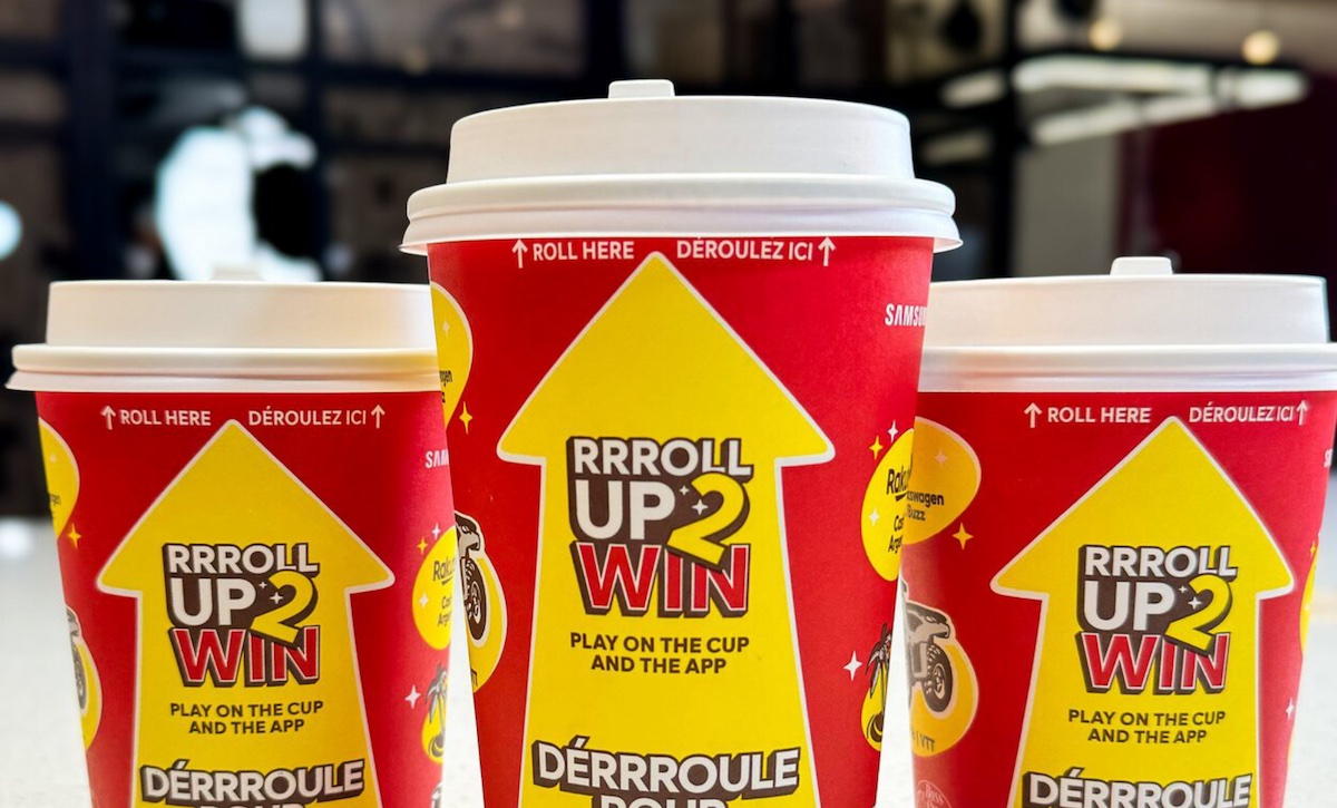 Three Tim Horton's "Roll Up The Rim To Win" disposable coffee cups, in bright red and yellow.