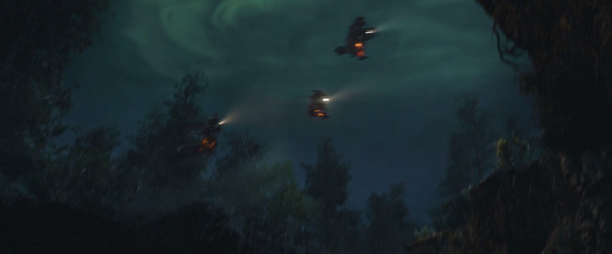 Three Star Wars kids jump over a ravine on Star Wars bikes, framed against a dark sky.